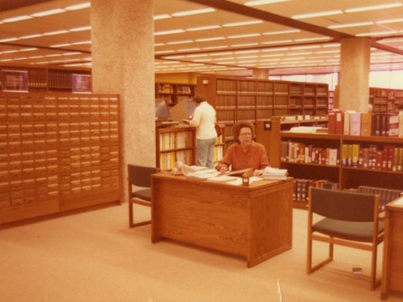 A librarian sits at a service desk in the Main Library.