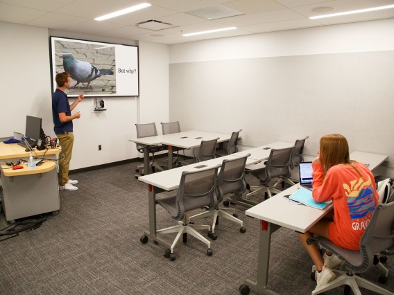 student giving a presentation in a presentation room